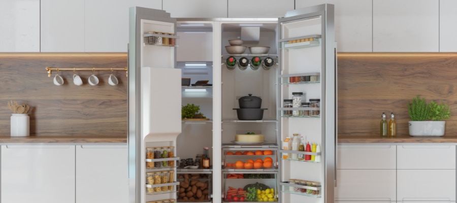 Person placing fresh food into a well-stocked home refrigerator